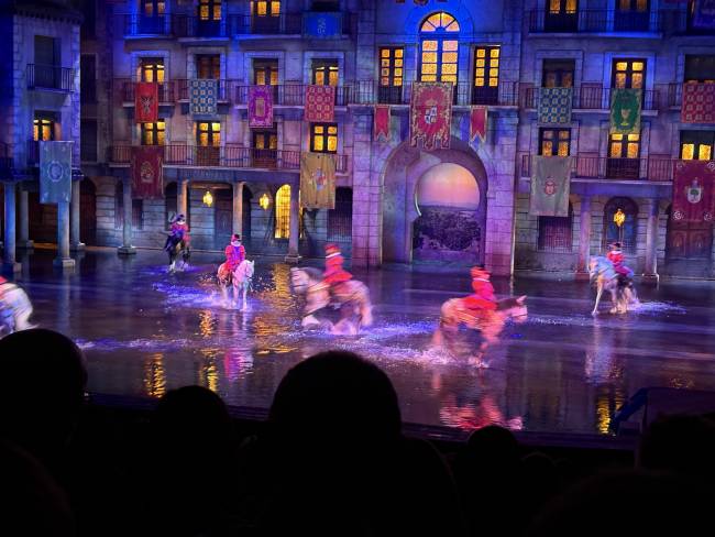 Horses trotting to music through the water